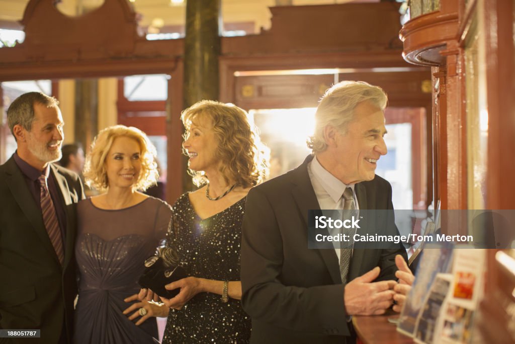 Well dressed couples at counter in theater lobby  Stage Theater Stock Photo