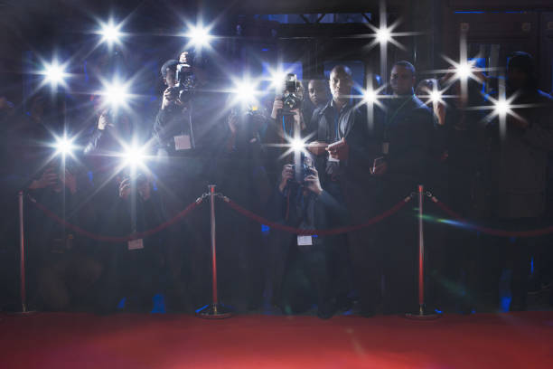 paparazzi utilizando fotos de flash detrás de cuerda con alfombra roja - front view flash fotografías e imágenes de stock