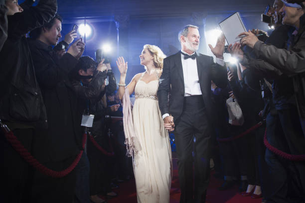 istock Well dressed celebrity couple walking through paparazzi on red carpet 188051865