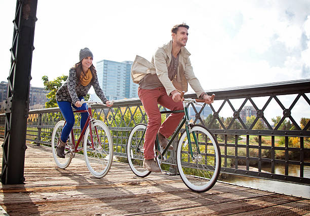 Urban Cyclists Young couple with urban bicycle in city park in Autumn. hipster bike stock pictures, royalty-free photos & images