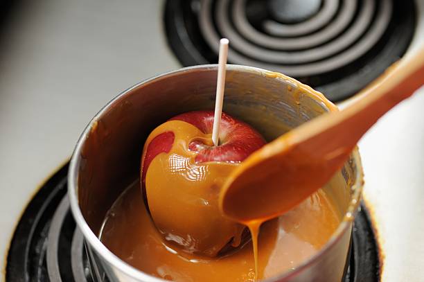 mojar red apple in suflé de caramelo - drop red delicious apple apple fruit fotografías e imágenes de stock