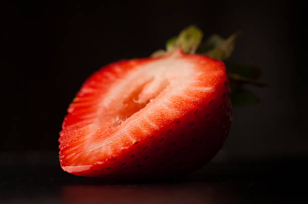 Strawberry slice on black stock photo