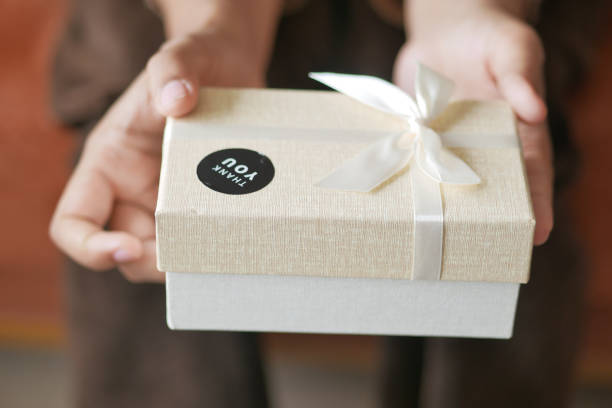 istock hand putting a thank you sticker on a gift box 1880562043