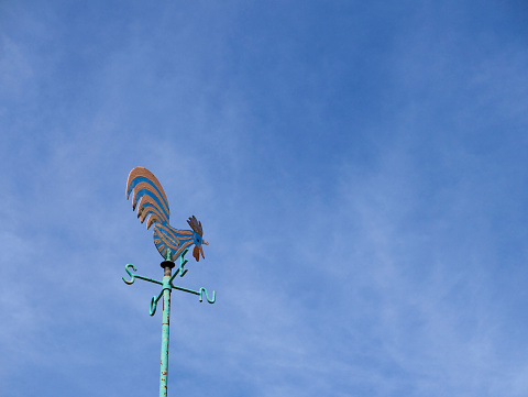 The weathervane rooster with blue sky