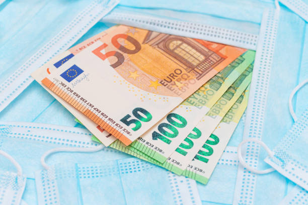 istock Euro Banknotes with Blue Disposable Medical Face Masks 1880630846