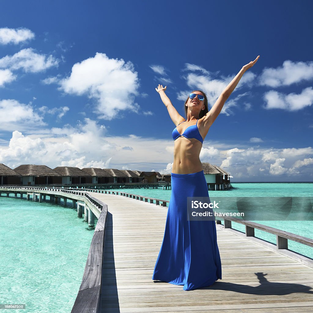 Woman on a beach jetty at Maldives Woman on a tropical beach jetty at Maldives Adult Stock Photo