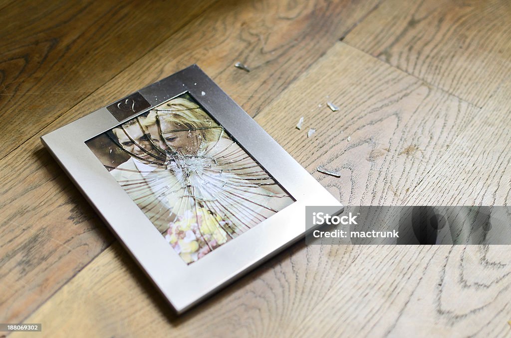 Broken picture frame with married couple Broken image frame of happily married couple shattered on wooden floor Broken Stock Photo
