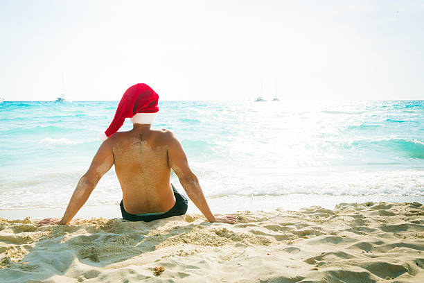 istock man in santa hat on the beach 188071109