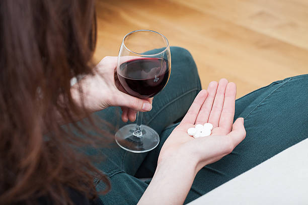 femme avec un verre de vin et de drogues - alcohol drug abuse alcoholism pill photos et images de collection