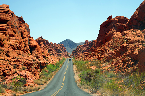 country road and vehicle in red desert valley