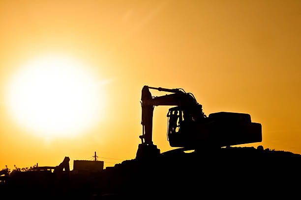istock Digger with construction worker in front of giant sun 188075618