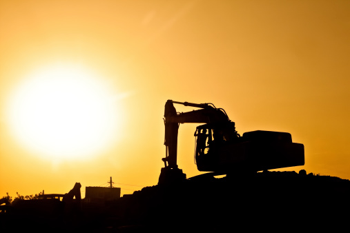 Excavator loader model with silhouette on sunset at over city building,Concepts Double exposure