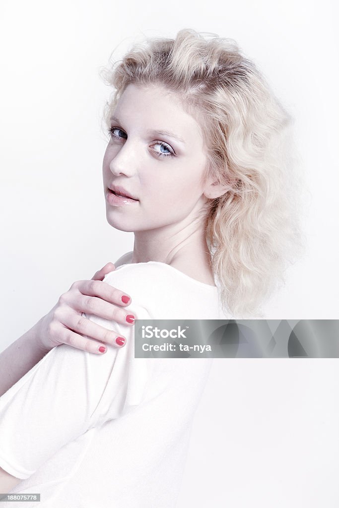 Beautiful woman Attractive young blond woman with beautiful natural neutral make-up and curly short hair wearing white top. Fashion model studio portrait on light background. 20-24 Years Stock Photo