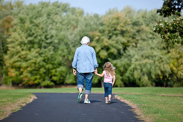 Girl & Grandma Walking in Park