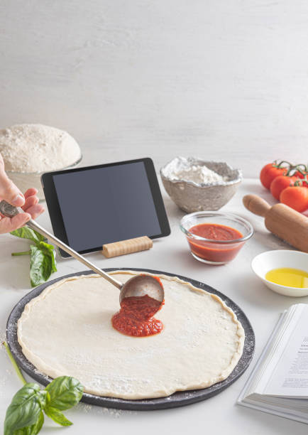 istock Raw dough for pizza with ingredient: tomato sauce, dough, mozzarella, tomatoes, basil, olive oil, spices served on rustic marble table 1880829556