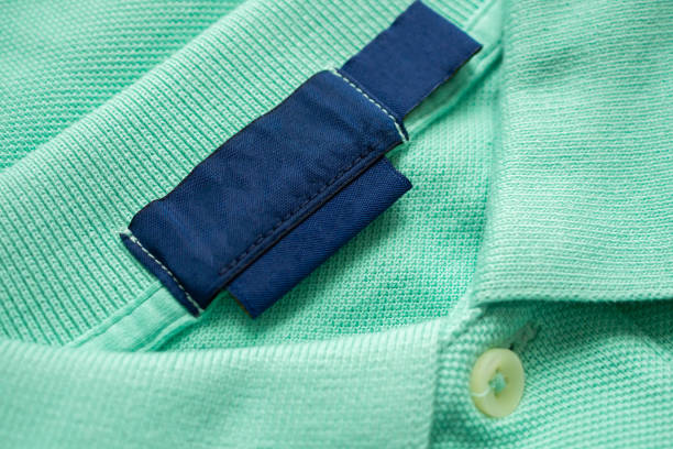 istock Blank blue laundry care clothes label on green shirt fabric texture background 1880830064