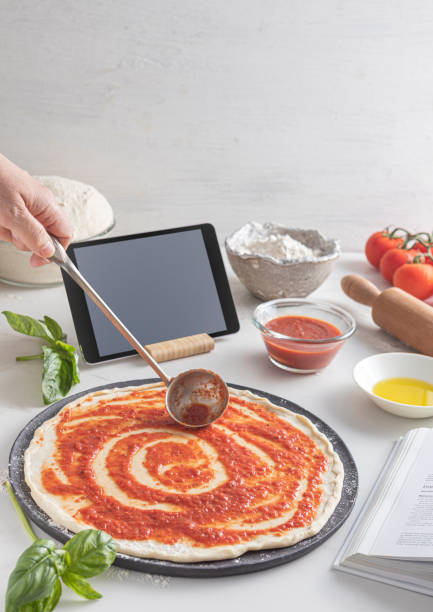 istock Spreading tomato sauce on pizza pan 1880830083