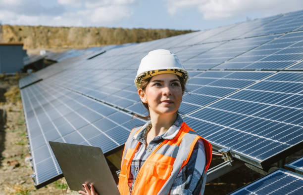istock Young female maintenance engineer working at solar energy power farm 1880850531