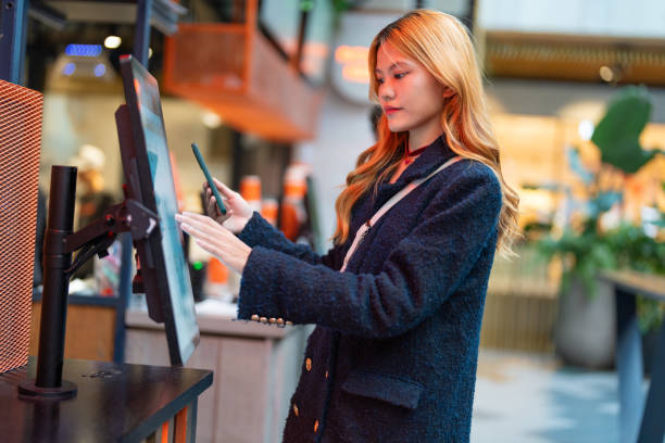 istock young asian female using mobile for payment on kiosk 1880917554