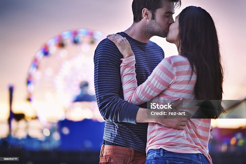 young couple kissing near santa monica pier photo of a young couple kissing near santa monica pier at sunset Adult Stock Photo