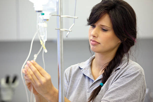 женский медицинский помощник готовится инфузии - infused oil iv drip nurse hospital стоковые фото и изображения