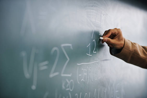 It's all in the formula... Cropped image of a teacher writing a formula on a blackboard algebra photos stock pictures, royalty-free photos & images