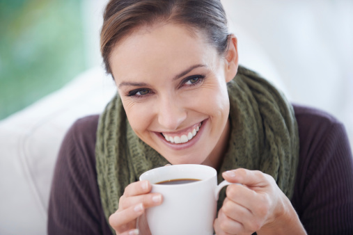 A young woman holding a cup of coffee - closeup