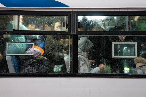 Ulaanbaatar, Mongolia - November 8, 2023: Commuters on a packed bus during peak hour.