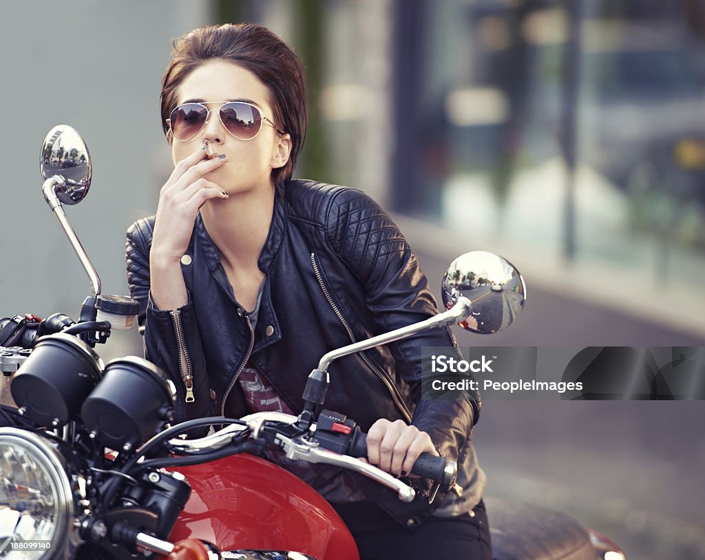 Don't mess with her Shot of a young female biker smoking a cigarette 20-24 Years Stock Photo