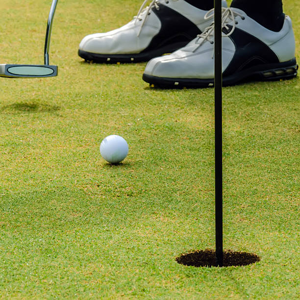istock golfer putting a golf ball in to hole 188100405