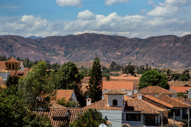 A view looking down on tiled roof tops of the little town of Barichara, mountains in the background. Barichara is a town in northern Colombia known for its cobbled streets and colonial architecture and a very popular tourist destination.