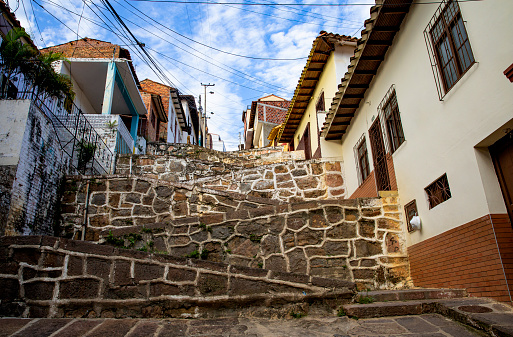 A patterned concrete outdoor staircase running up a hill with house on either side in the famous little town of Barichara.  Barichara is a town in northern Colombia known for its cobbled streets and colonial architecture and a very popular tourist destination.