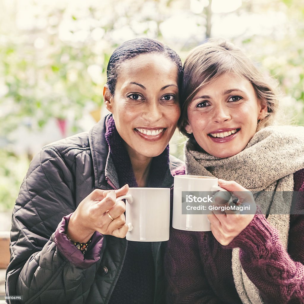 Zwei Frauen mittleren Alters beim Anstoßen mit warmen Kaffee - Lizenzfrei Freundschaft Stock-Foto