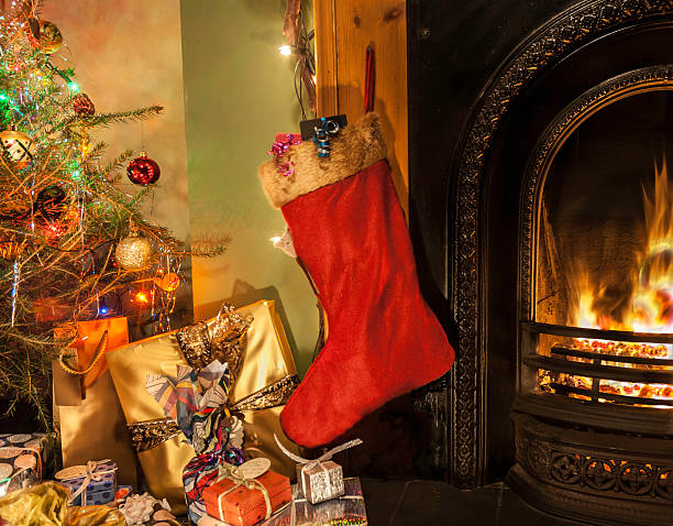 istock Christmas stocking along the fireplace surrounded by gifts 188108870