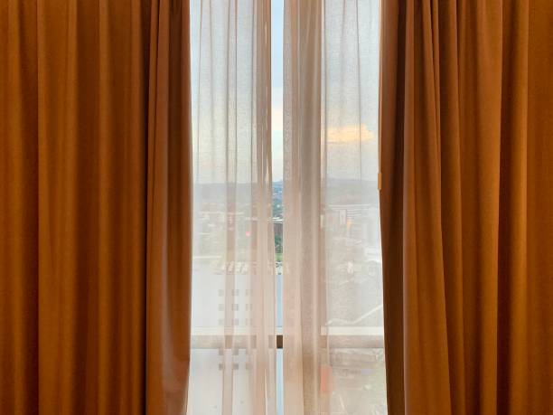 istock City view behind hotel room curtain 1881129804