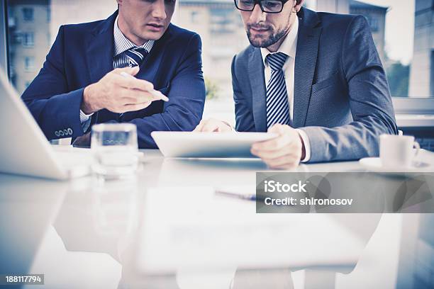 Two Businessmen Having A Discussion And Using Tablet Stock Photo - Download Image Now