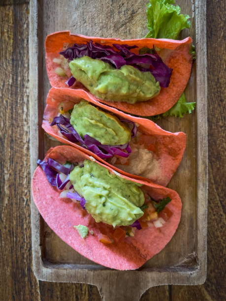 three vegan tacos filled with hummus, guacamole, salsa, red cabbage - guacamole food bar vegan food imagens e fotografias de stock