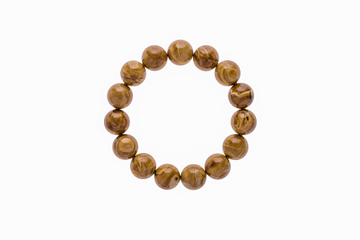 A circular bracelet composed of polished Root Amber, also known as Burmite, isolated on a white background