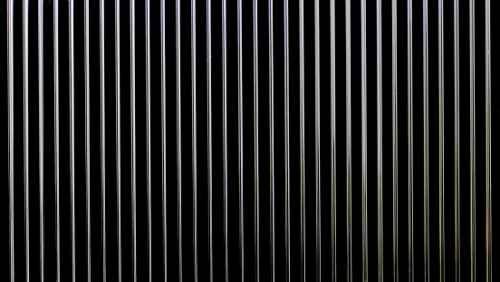 close up of a metal grill on a black background