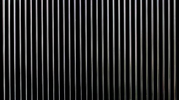 close up of a metal grill on a black background