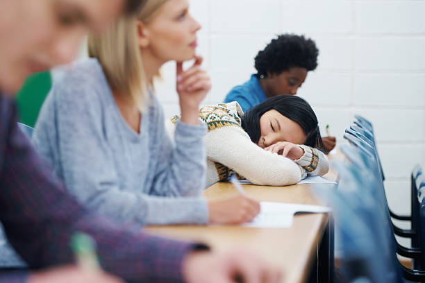 It was a late one last night Shot of a university student falling asleep while listening to a lecture male college student sleeping through lecture stock pictures, royalty-free photos & images