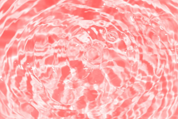 istock Red water splashes on the surface ripple blur. Defocus blurred transparent purple colored clear calm water surface texture with splash and bubble. Water waves with shining pattern texture background. 1881240063