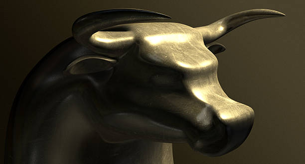 Bull Market Bronze Casting Contrast A closeup of a bronze casting depicting a stylized bull in contrasting light representing a bull financial market on a isolated dark background bull market stock pictures, royalty-free photos & images