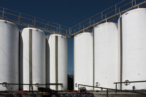 Storage tanks and deep blue sky in the background in a drinks packing factory.