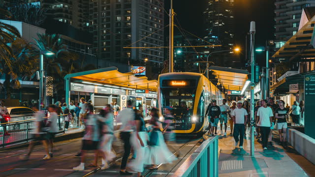 Time Lapse of Crowded Commuter and Tourist walking and crossing road at tram station around Cavill Avenue tram station public transport hub city street at night time in Gold Coast, Queensland, Australia
