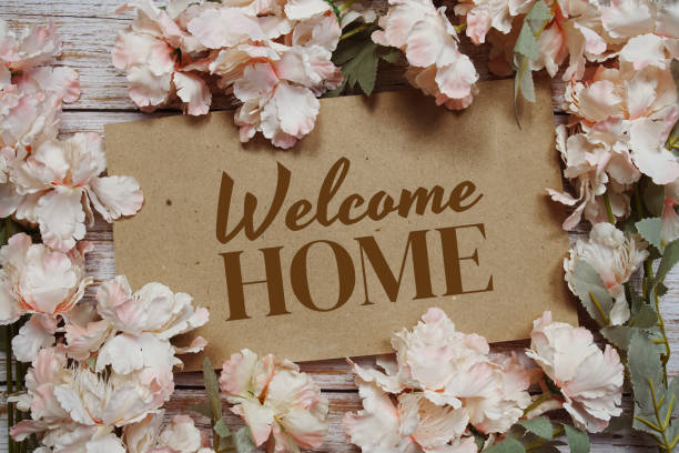 istock Welcome Home typography text with flowers frame on wooden background 1881319509