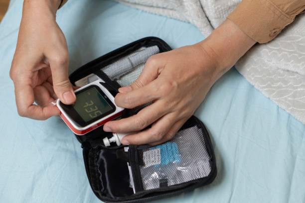 istock A woman's hand checking her blood sugar level with a glucometer by herself at her home. 1881378482