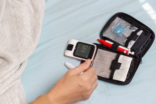 istock A woman's hand checking her blood sugar level with a glucometer by herself at her home. 1881378994