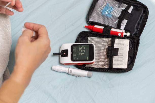 istock A woman's hand checking her blood sugar level with a glucometer by herself at her home. 1881380045