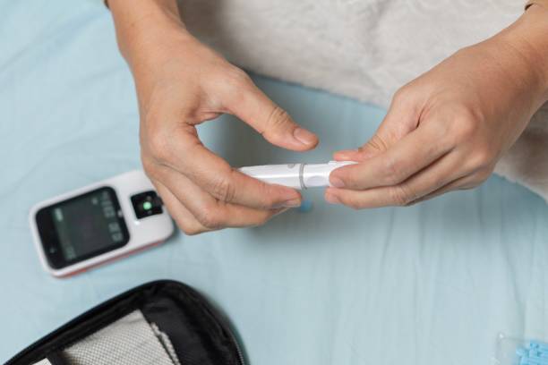 istock A woman's hand checking her blood sugar level with a glucometer by herself at her home. 1881382106